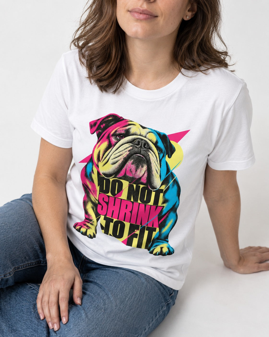 English Bulldog Don't Shrink to Fit T-Shirt in White, worn by a seated model