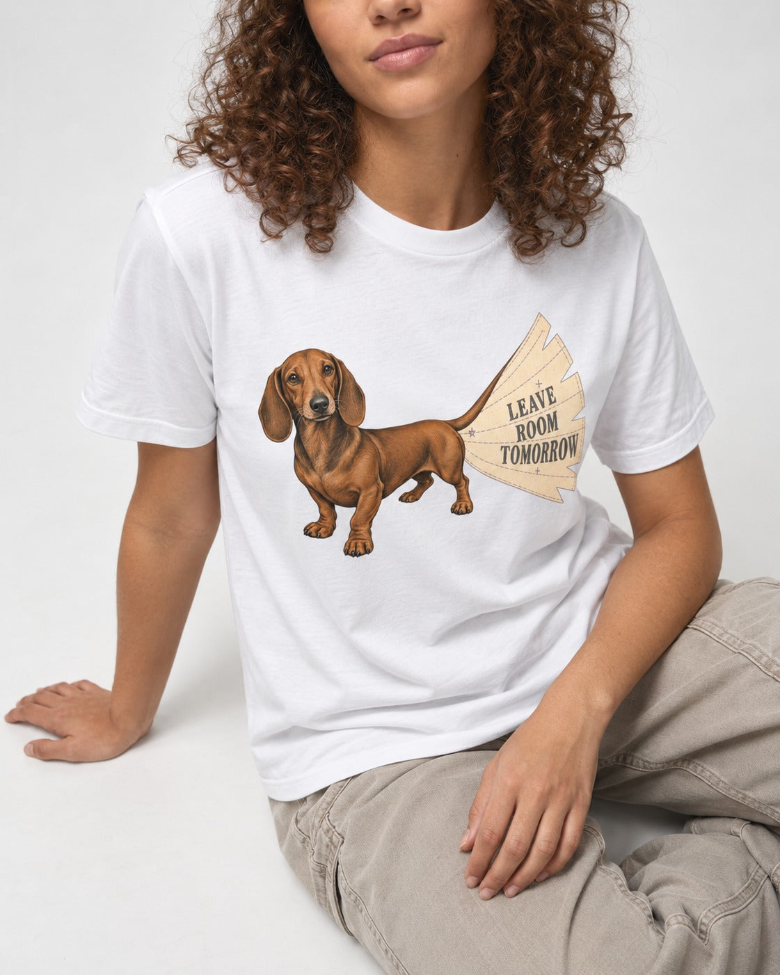 Dachshund Leave Room Tomorrow T-Shirt in White, worn by a seated model