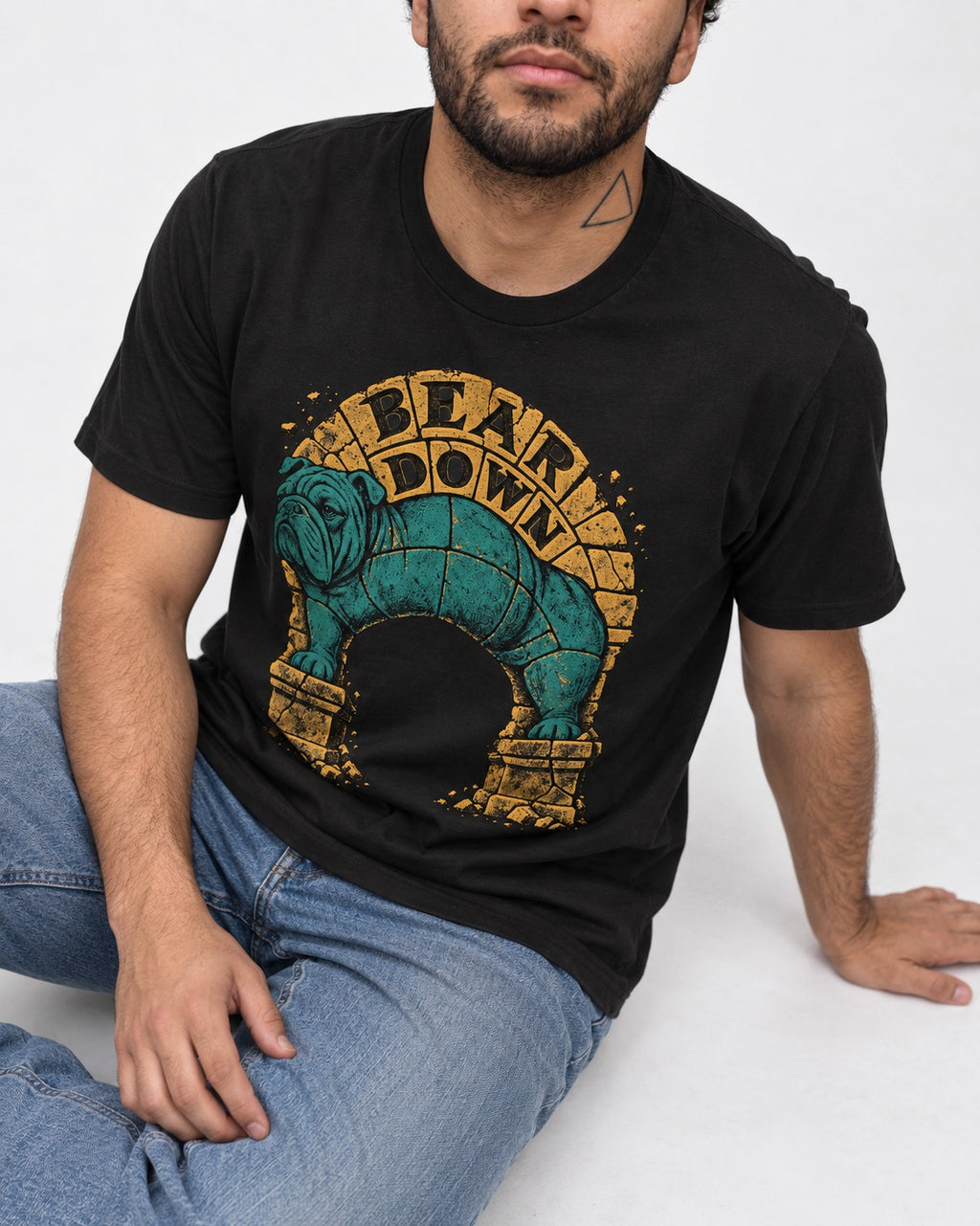 English Bulldog Bear Down Stone Arch Graphic T-Shirt in Black, worn by a seated model