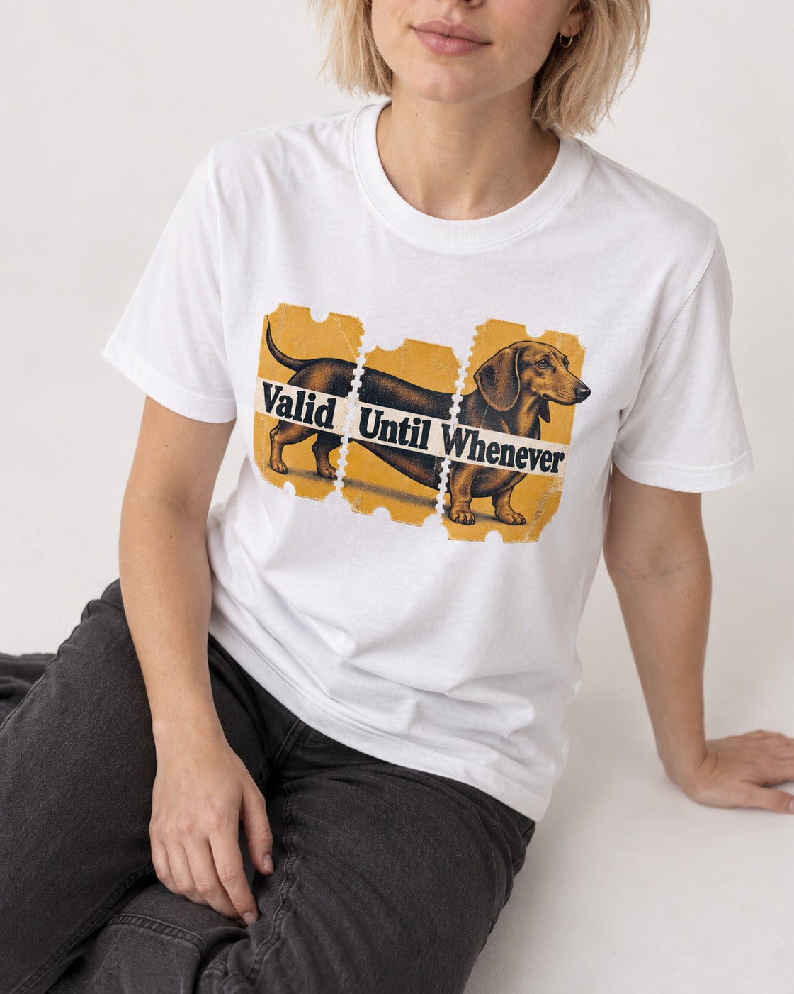 Dachshund Valid Until Whenever T-Shirt in White, worn by a seated model