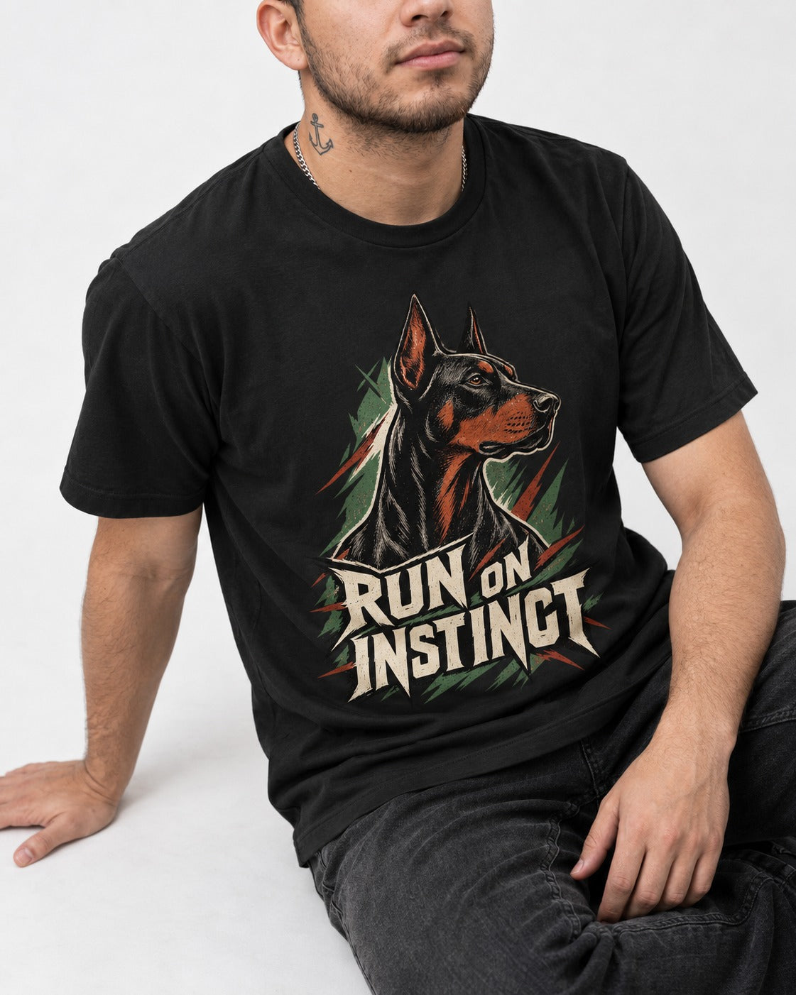 Doberman Run on Instinct Brush Slash Graphic T-Shirt in Black, worn by a seated model