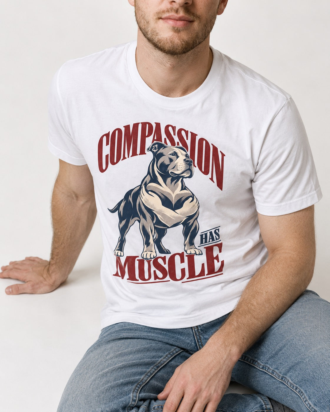Pitbull Compassion Has Muscle T-Shirt in White, worn by a seated model