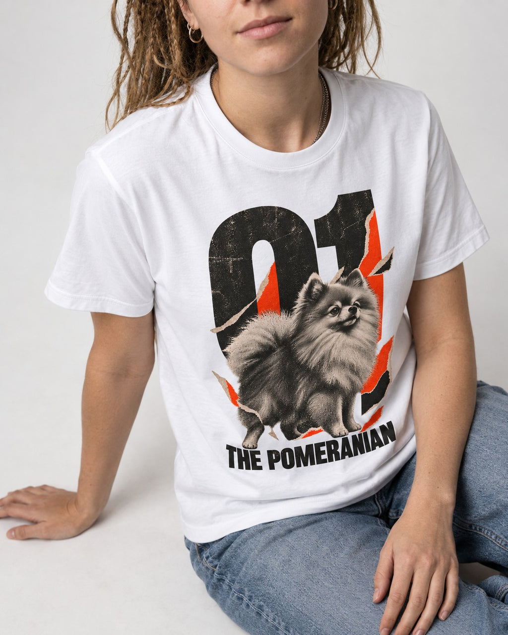 The Pomeranian T-Shirt in White, worn by a seated model