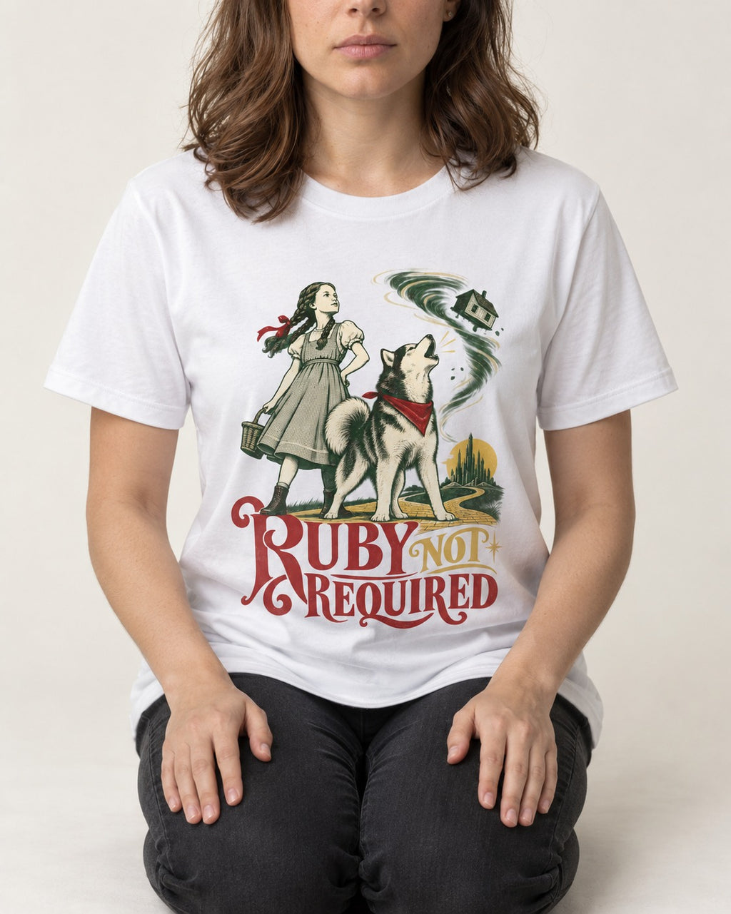 Ruby Not Required for Husky T-Shirt in White, worn by a seated model