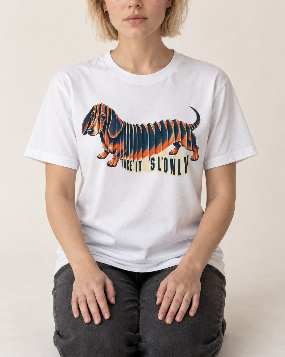 Take It Slowly Dachshund T-Shirt in White, worn by a seated model