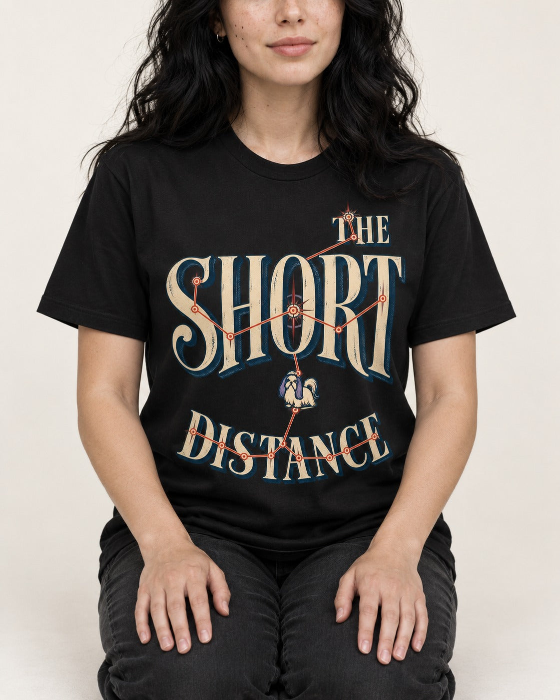 Shih Tzu The Short Distance Route Graphic T-Shirt in Black, worn by a seated model