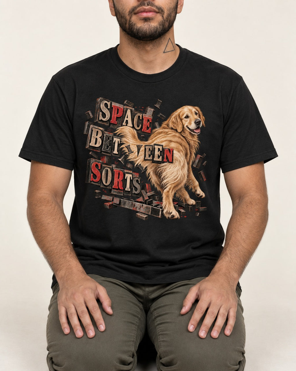 Golden Retriever Space Between Sorts Letterpress Graphic T-Shirt in Black, worn by a seated model