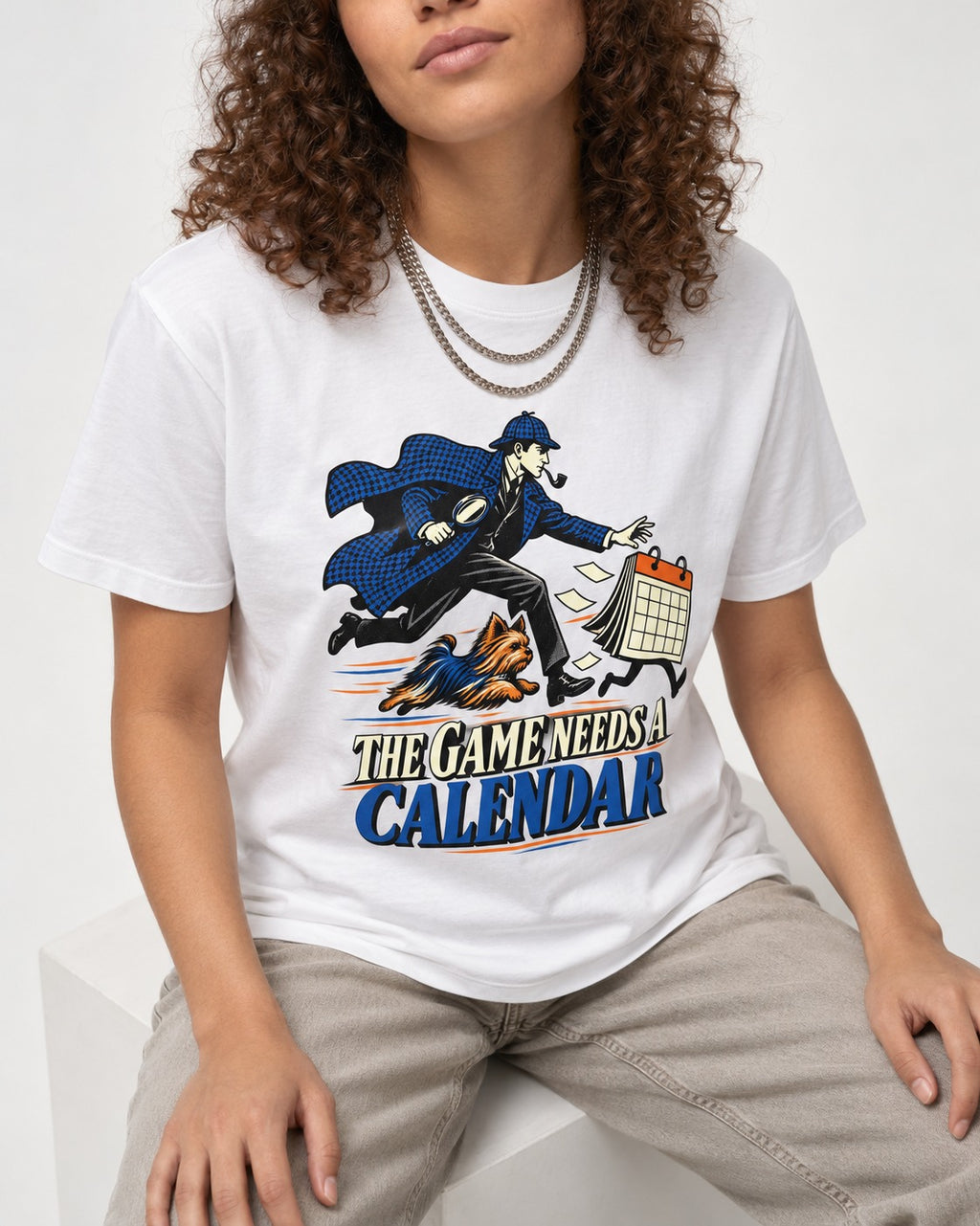 Yorkshire Terrier Game Needs a Calendar T-Shirt in White, worn by a seated model