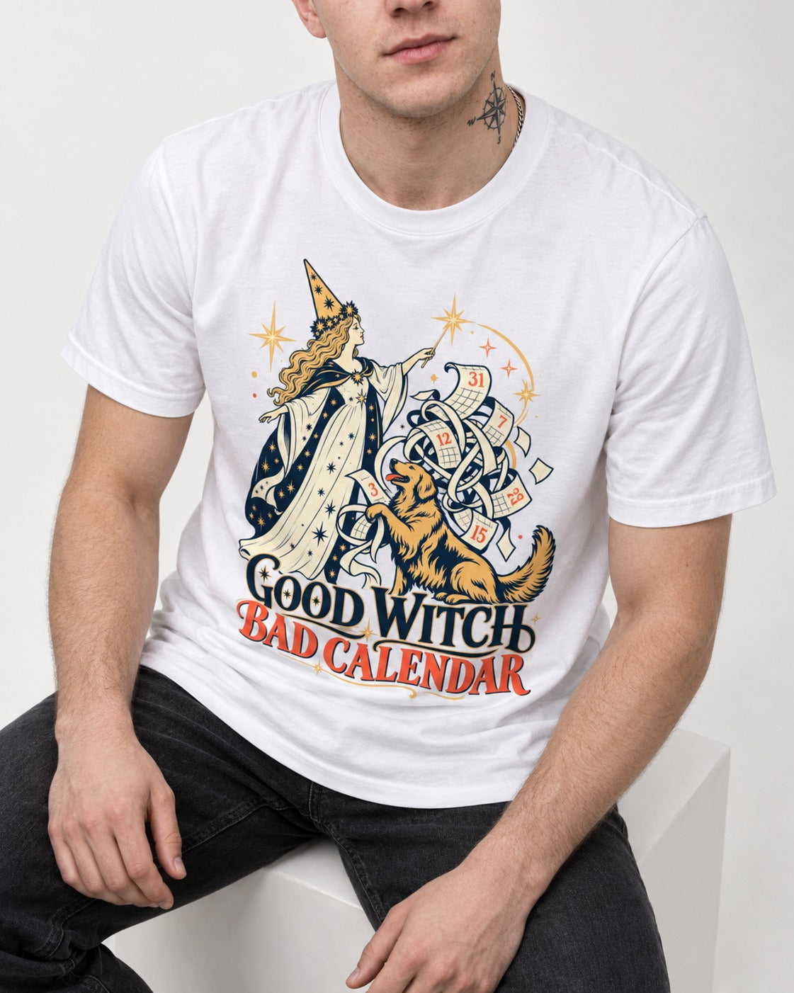 Good Witch Bad Calendar Golden Retriever T-Shirt in White, worn by a seated model