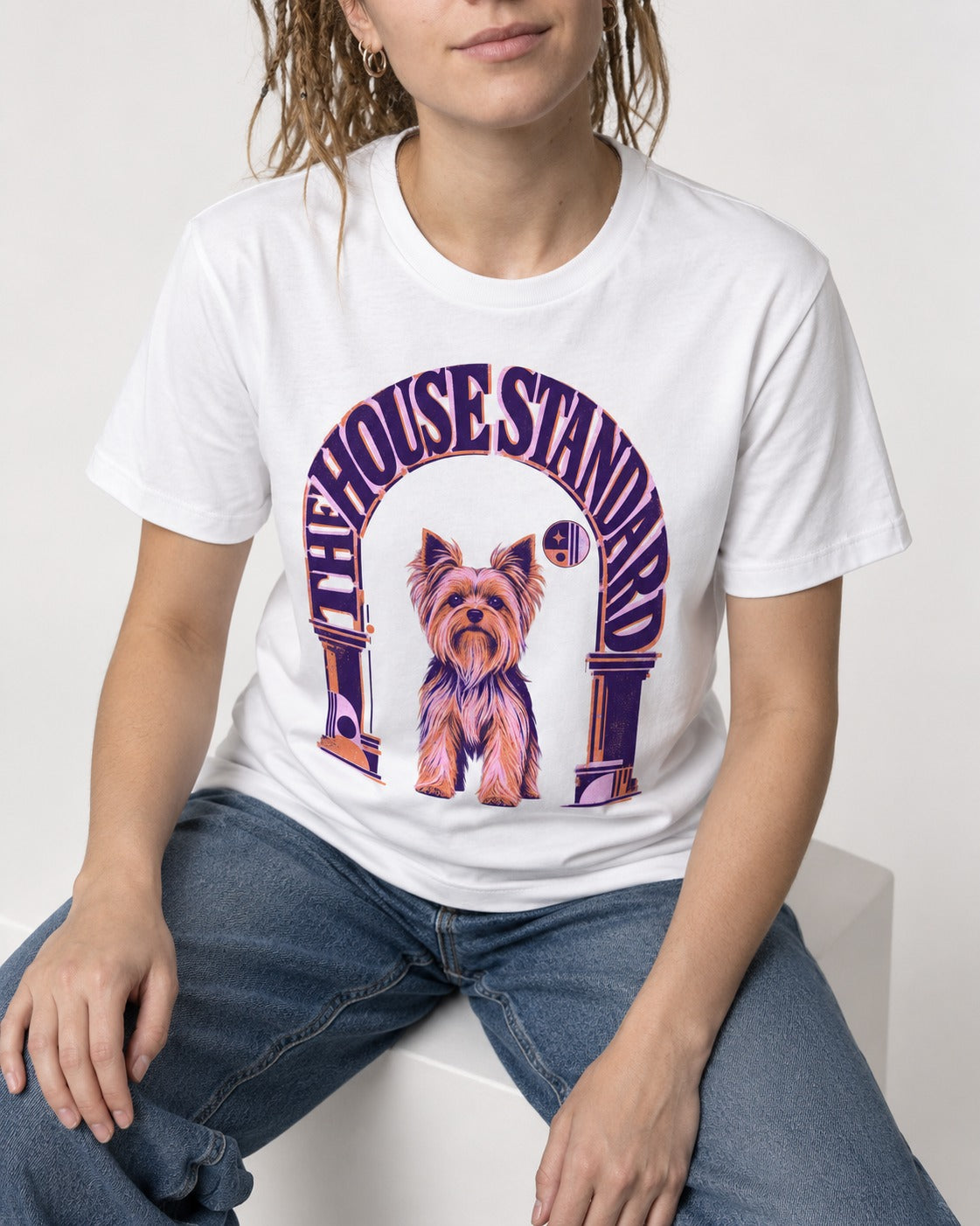 The Yorkshire Terrier House Standard T-Shirt in White, worn by a seated model