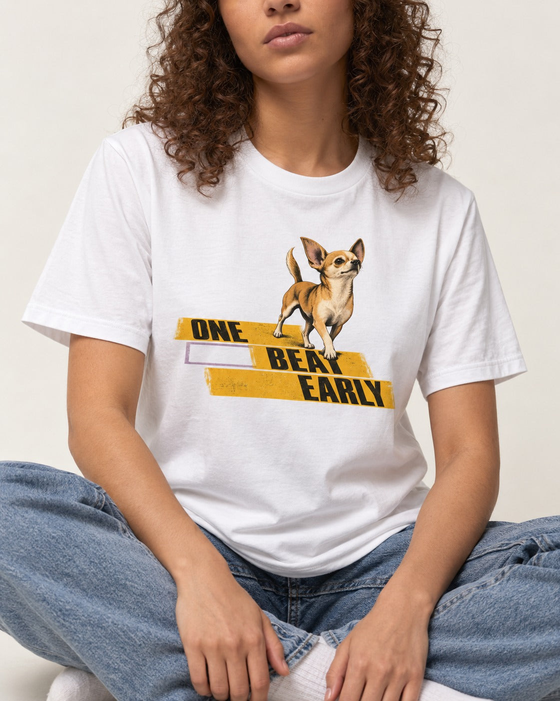 One Beat Early Chihuahua T-Shirt in White, worn by a seated model