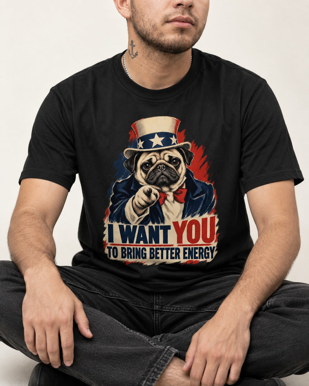 Pug I Want You to Bring Better Energy Uncle Sam Graphic T-Shirt in Black, worn by a seated model