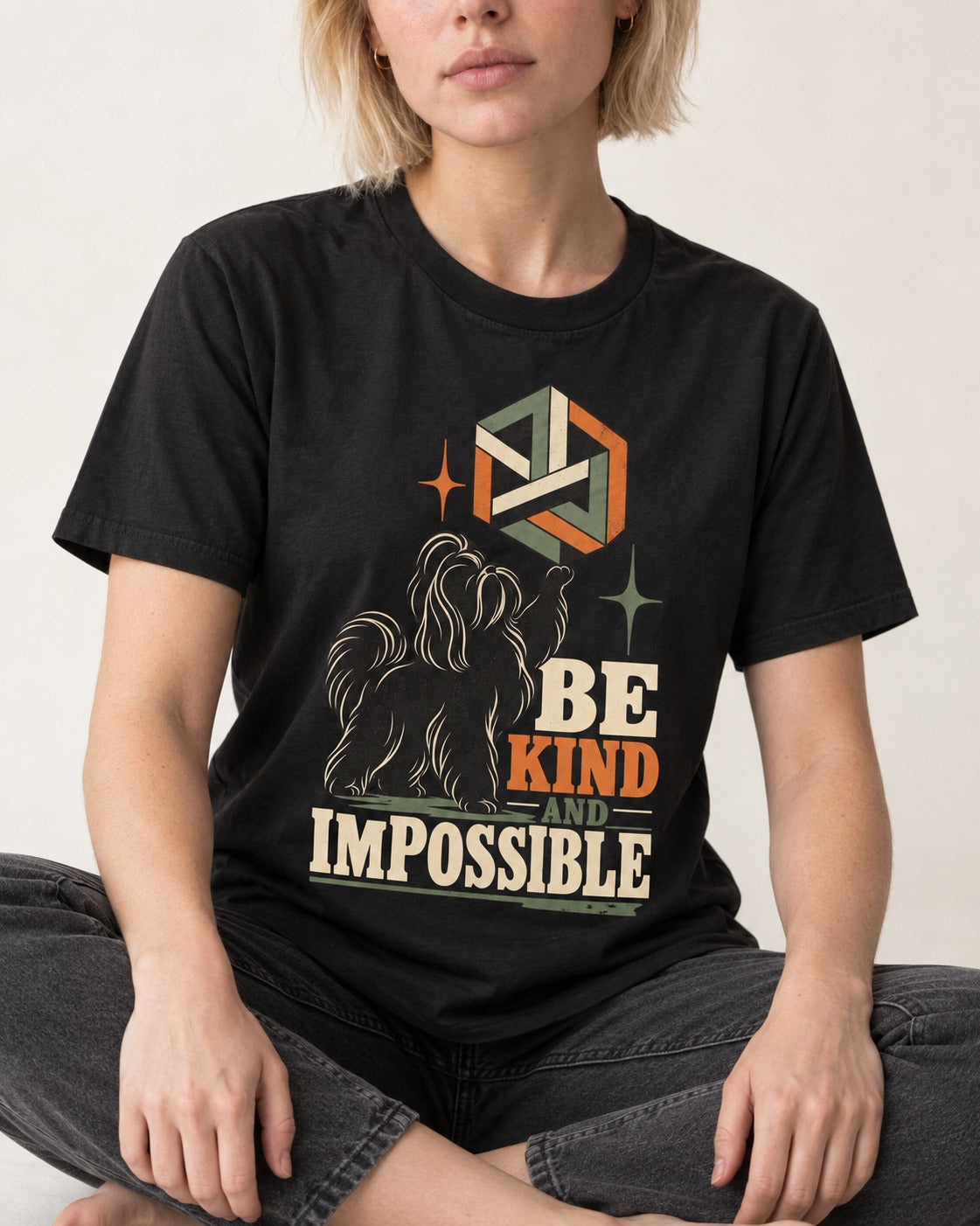 Shih Tzu Be Kind and Impossible Geometric Cube Graphic T-Shirt in Black, worn by a seated model