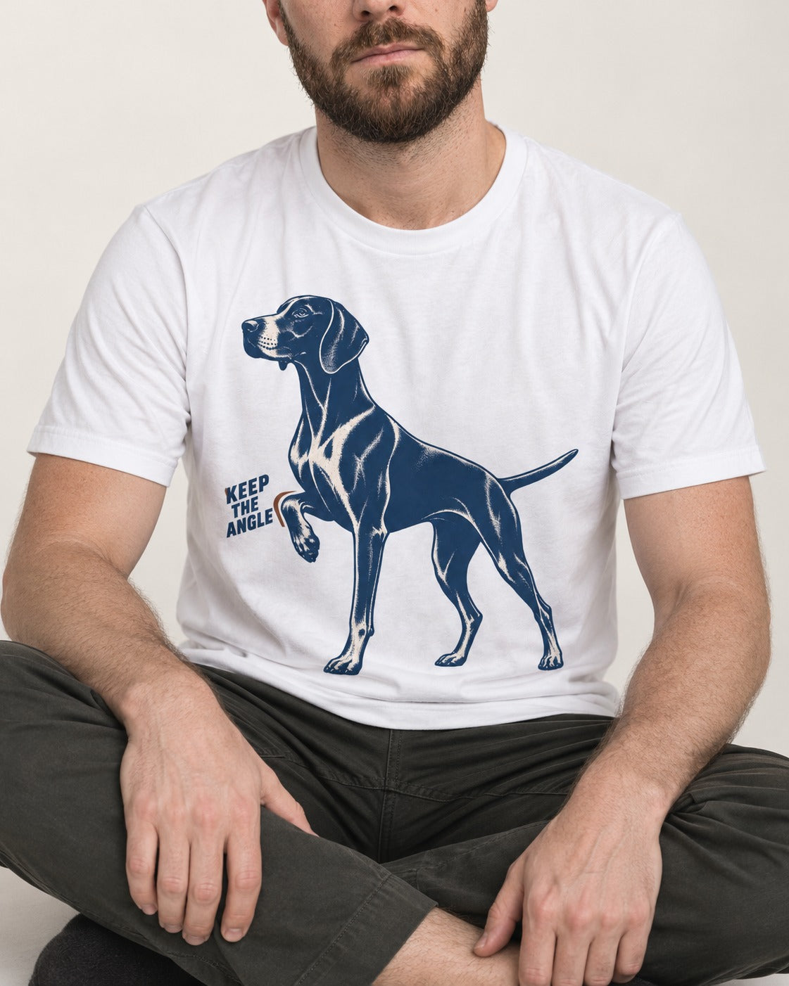Keep the Angle German Shorthaired Pointer T-Shirt in White, worn by a seated model