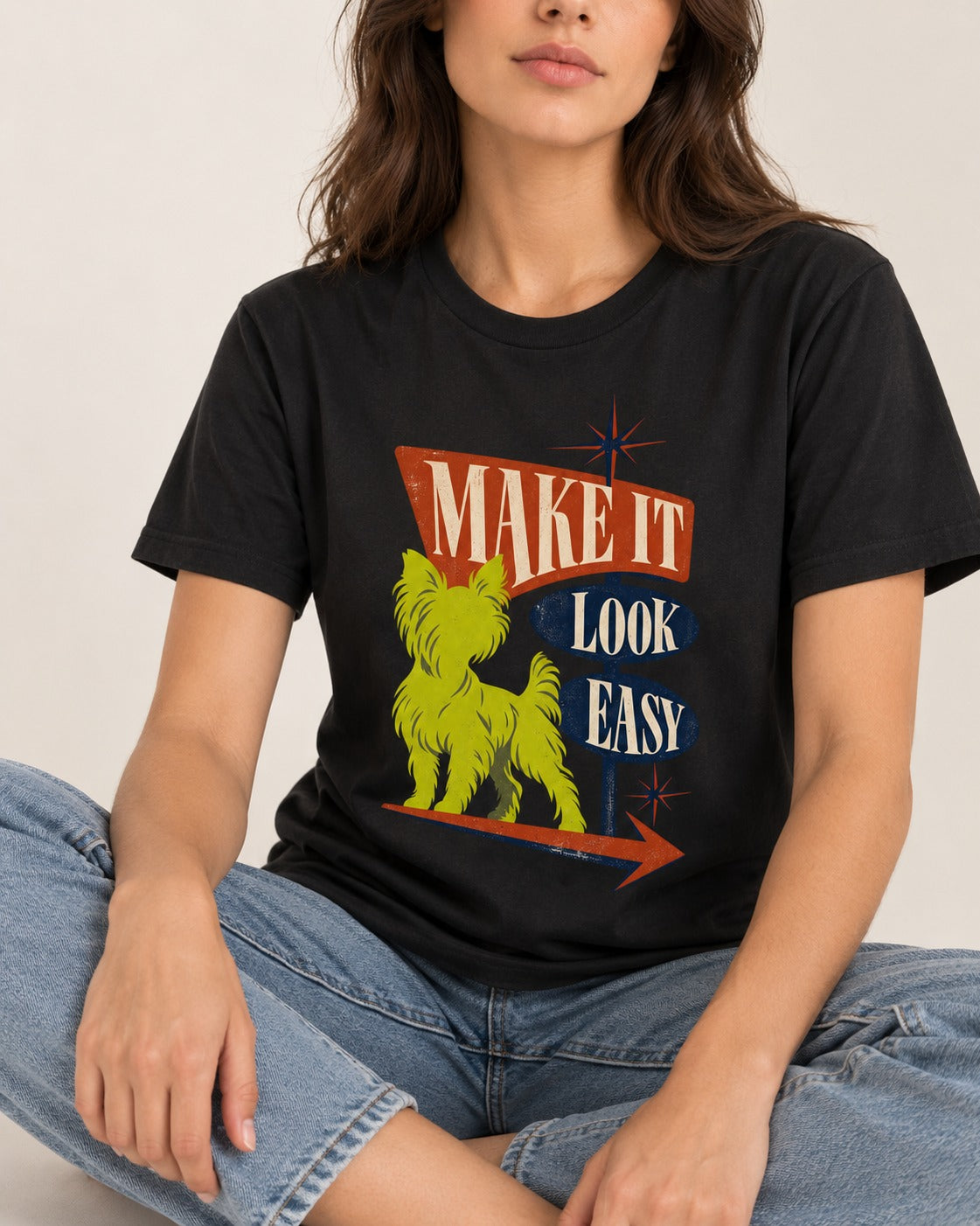 Yorkshire Terrier Make It Look Easy Retro Sign Graphic T-Shirt in Black, worn by a seated model
