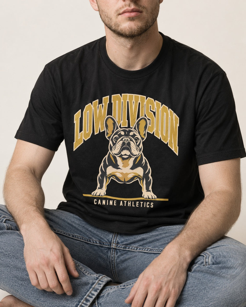 Frenchie Low Division Canine Athletics Graphic T-Shirt in Black, worn by a seated model