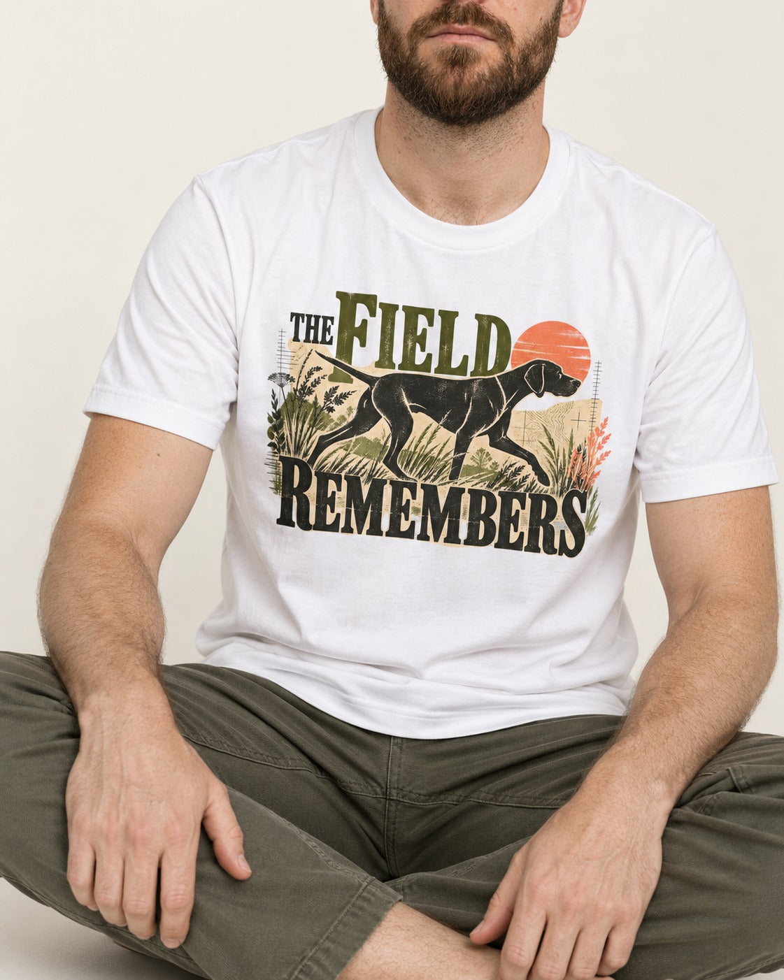 The Field Remembers German Shorthaired Pointer T-Shirt in White, worn by a seated model