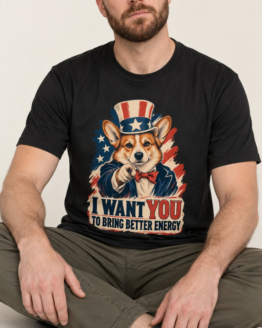Corgi I Want You to Bring Better Energy Uncle Sam T-Shirt in Black, worn by a seated model