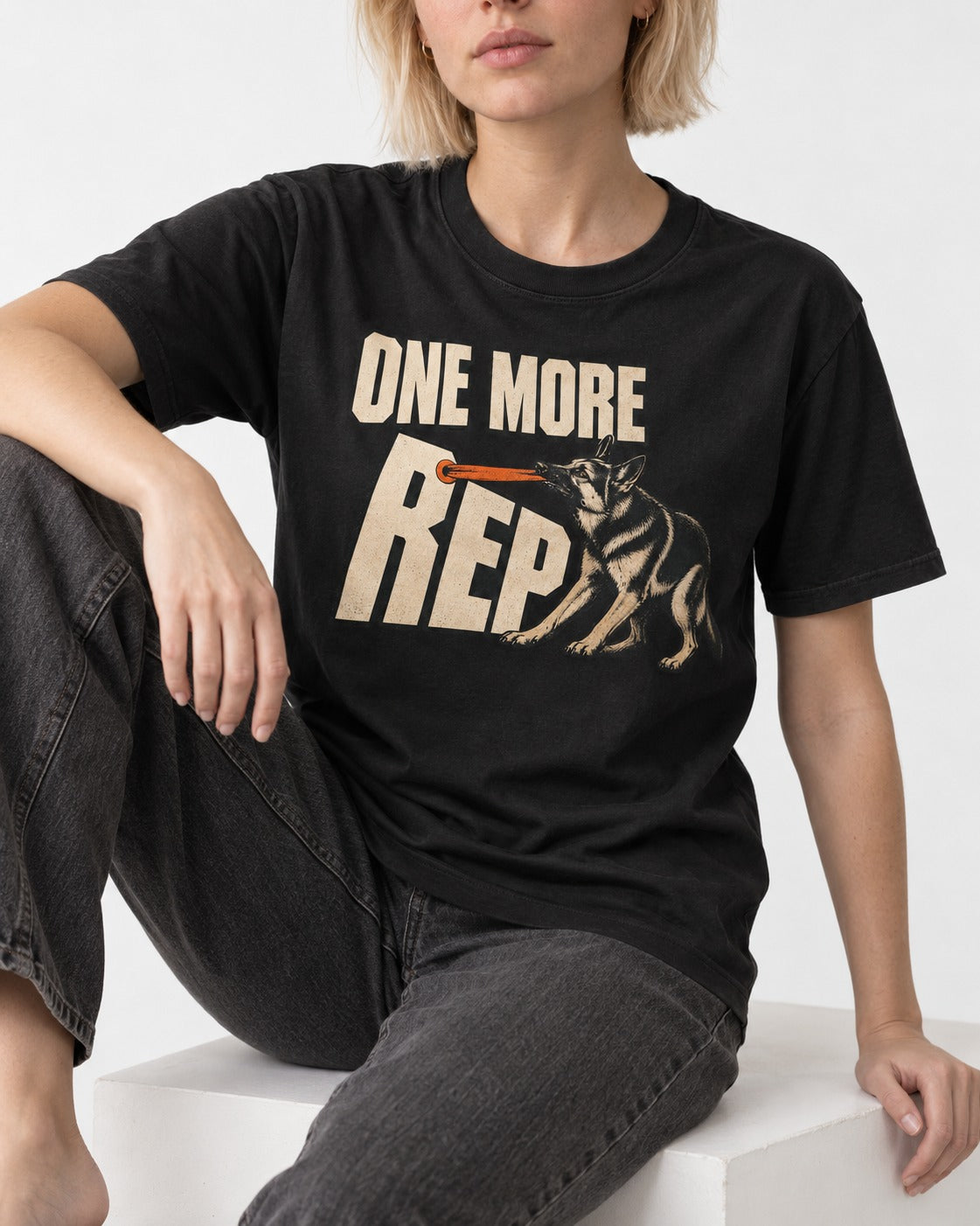 One More Rep Tug German Shepherd Dog Graphic T-Shirt in Black, worn by a seated model