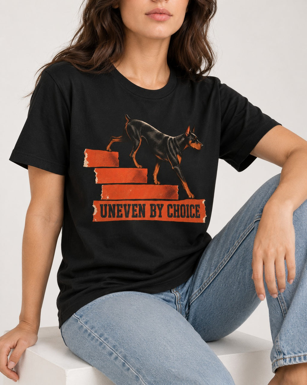 Doberman Uneven by Choice Stair Graphic T-Shirt in Black, worn by a seated model