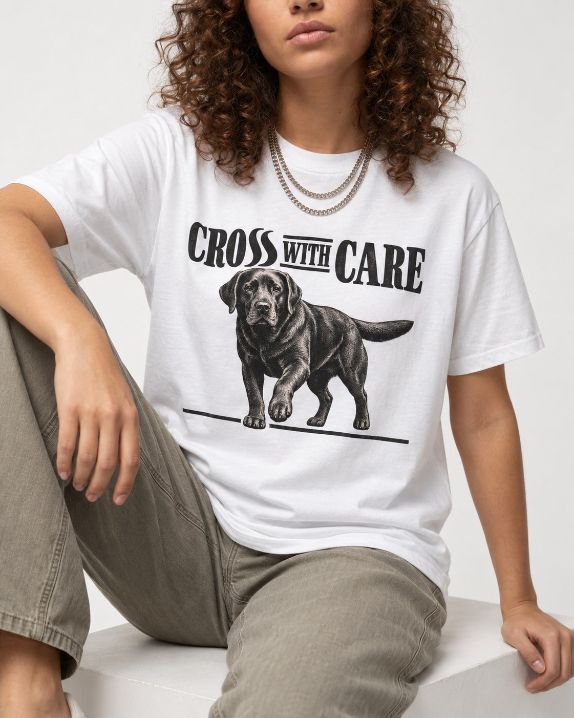 Labrador Retriever Cross with Care T-Shirt in White, worn by a seated model