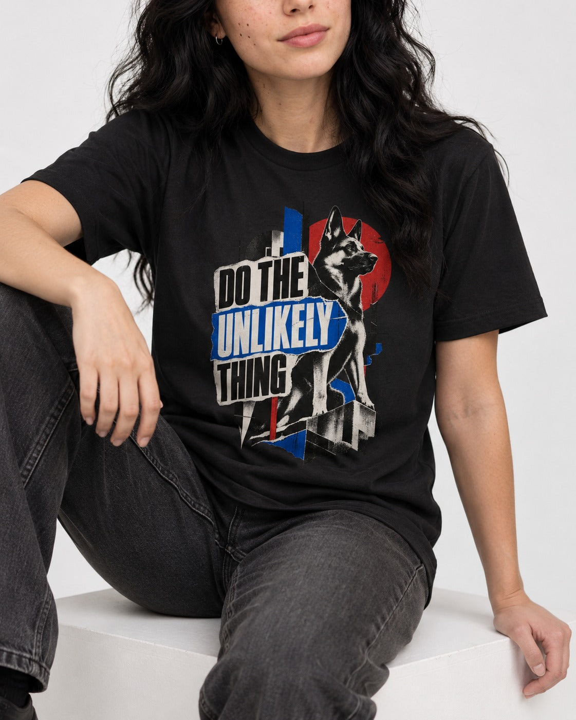Do The Unlikely Thing Torn Poster German Shepherd Dog Graphic T-Shirt in Black, worn by a seated model