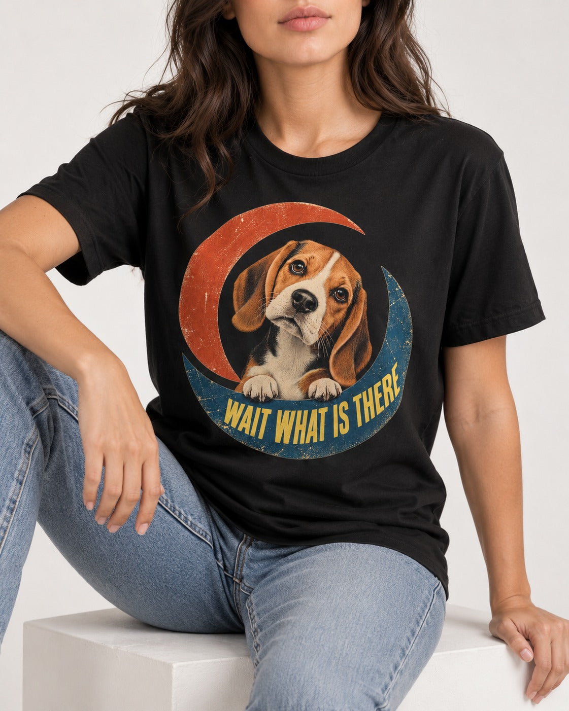 Wait What Is There Beagle Crescent T-Shirt in Black, worn by a seated model