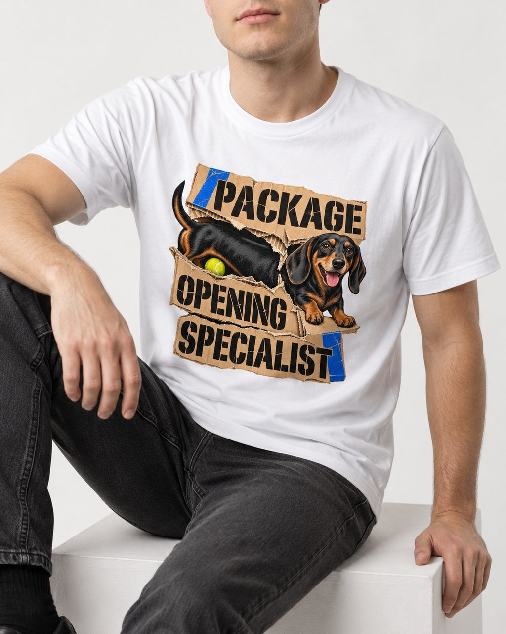 Dachshund Package Opening Specialist T-Shirt in White, worn by a seated model