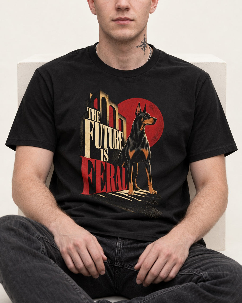 Doberman The Future Is Feral Art Deco Graphic T-Shirt in Black, worn by a seated model