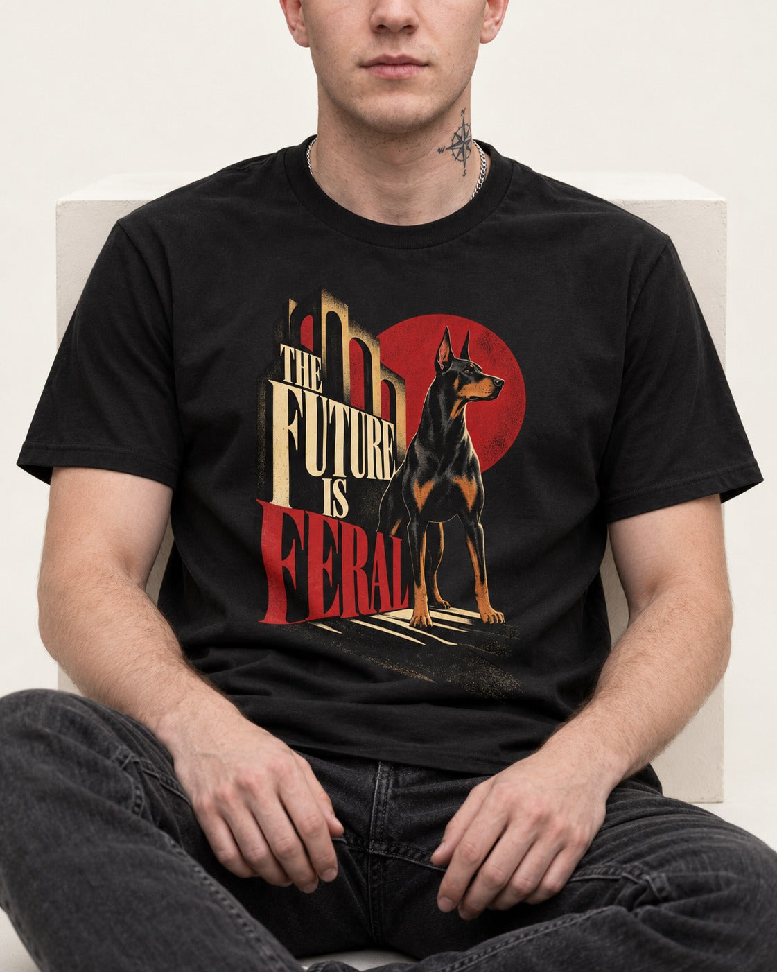 Doberman The Future Is Feral Art Deco Graphic T-Shirt in Black, worn by a seated model