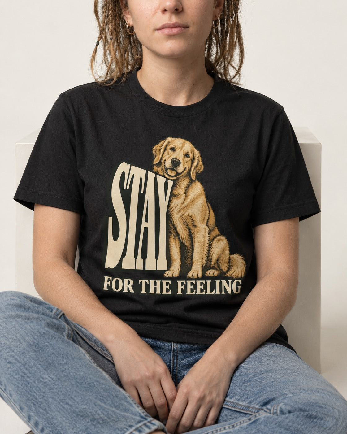 Golden Retriever Stay for the Feeling Leaning Puppy Graphic T-Shirt in Black, worn by a seated model