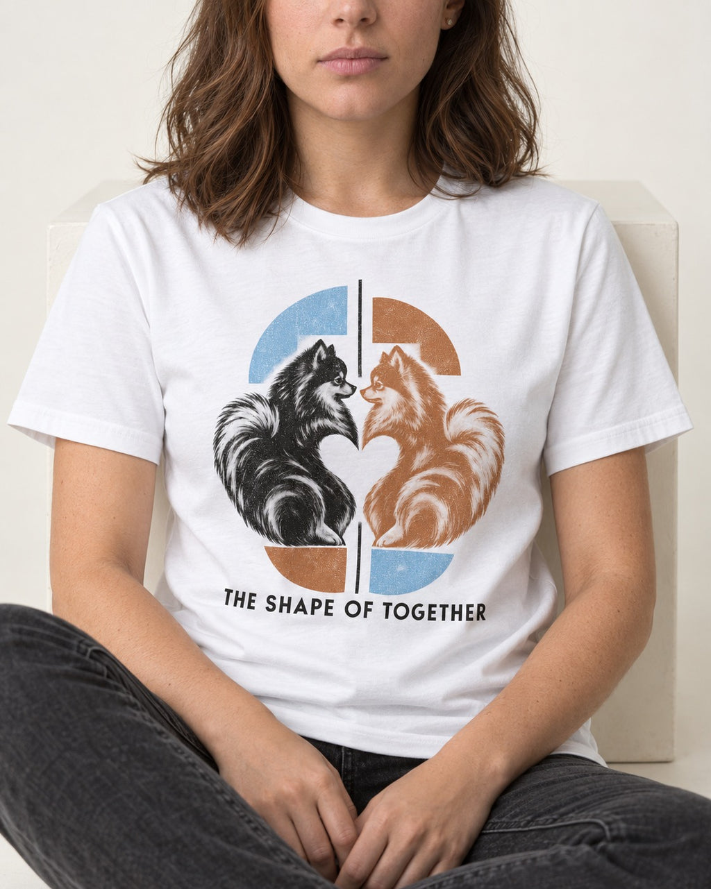Pomeranian The Shape of Together T-Shirt in White, worn by a seated model