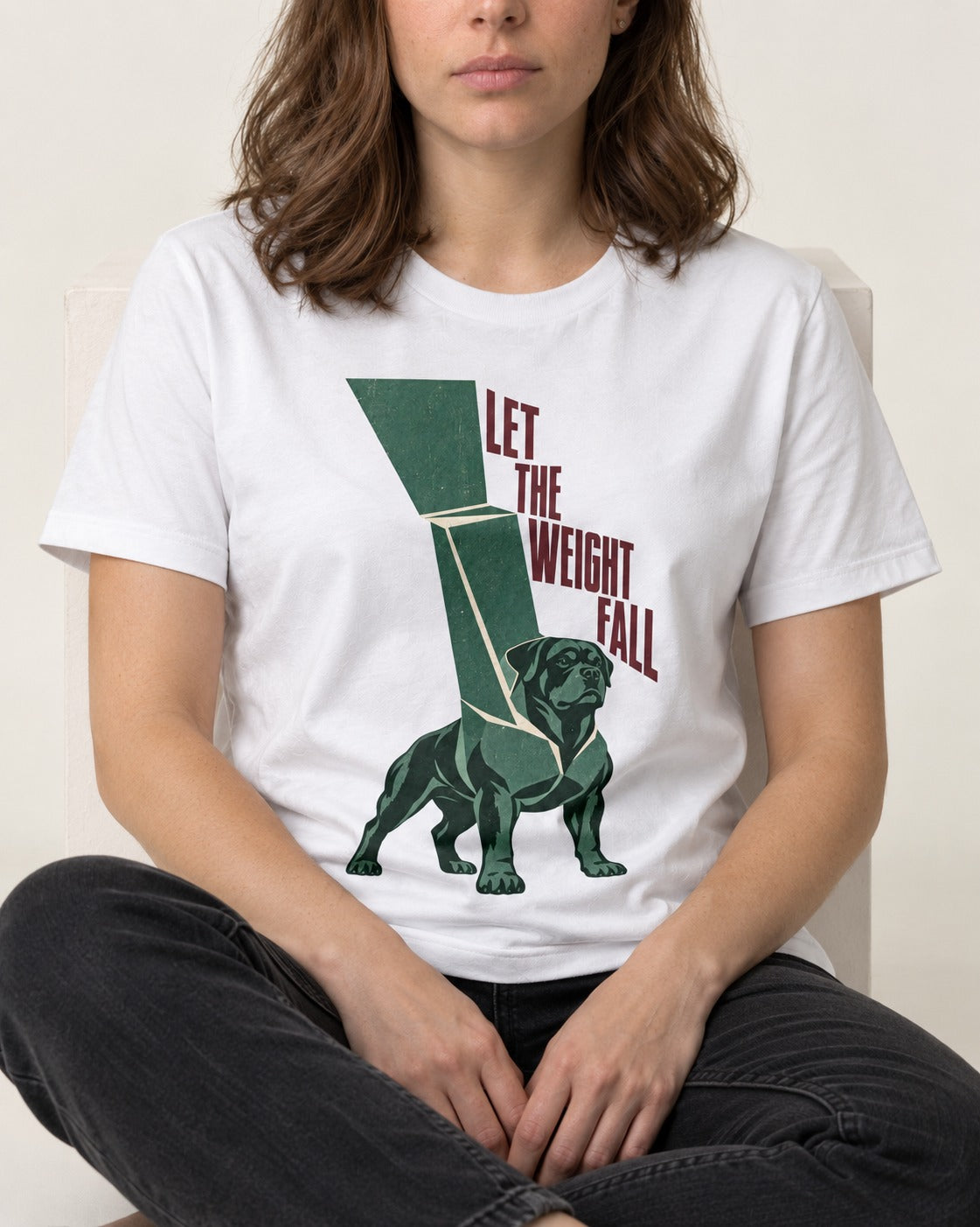 Let the Weight Fall Rottweiler T-Shirt in White, worn by a seated model
