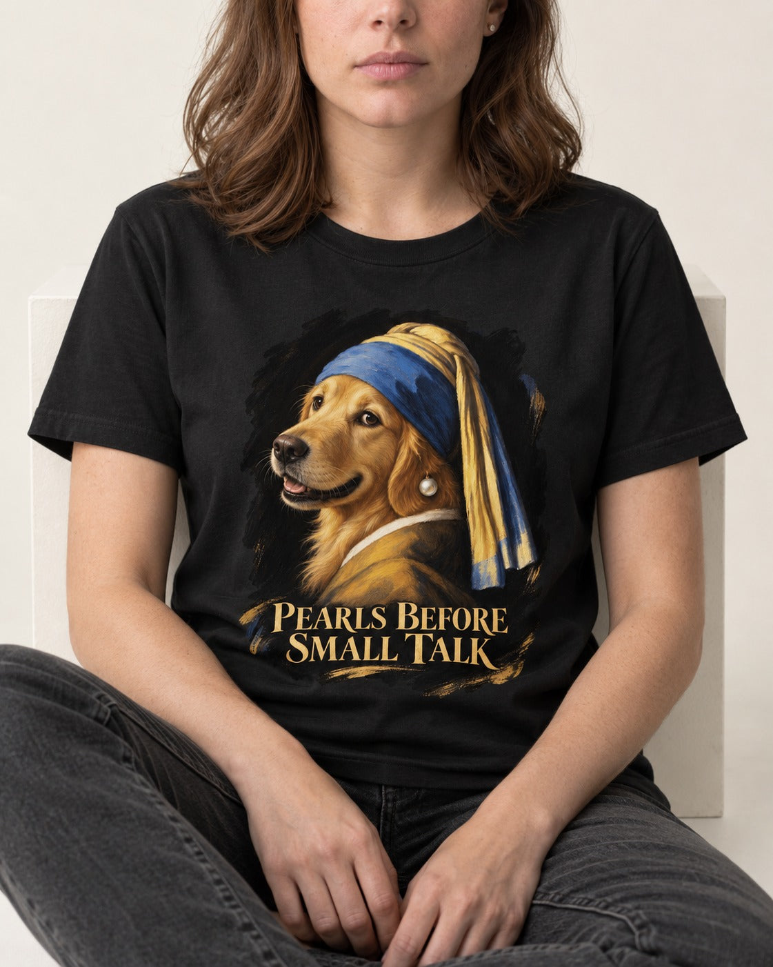 Pearls Before Small Talk Pearl Portrait Golden Retriever Graphic T-Shirt in Black, worn by a seated model