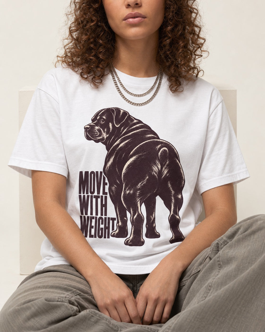 Rottweiler Moves with Weight T-Shirt in White, worn by a seated model