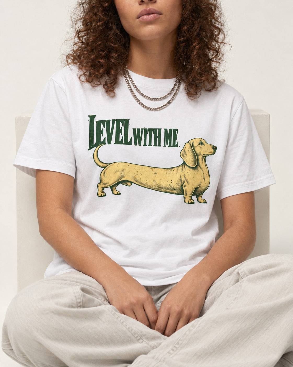 Dachshund Level with Me T-Shirt in White, worn by a seated model