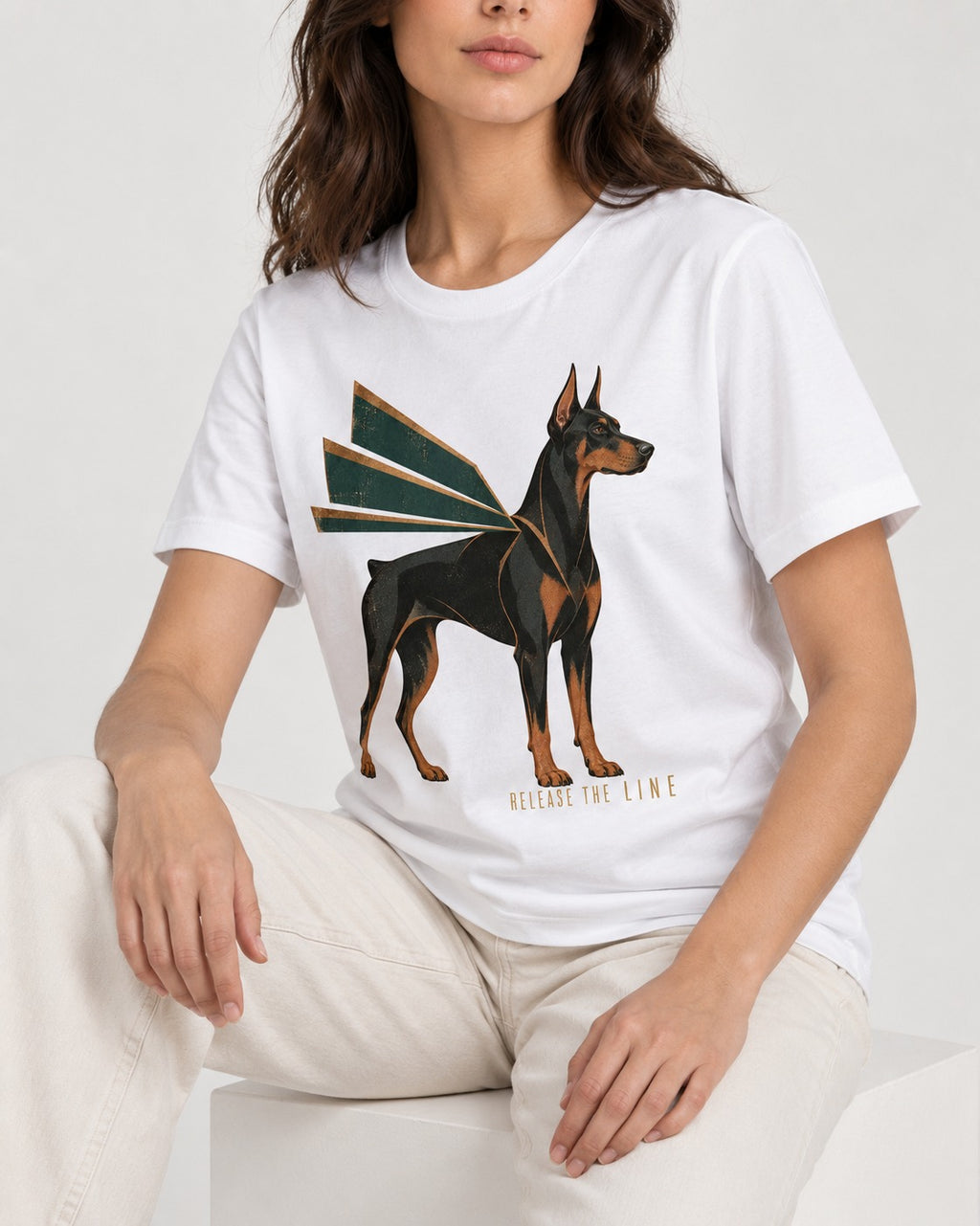 Release the Doberman Line T-Shirt in White, worn by a seated model