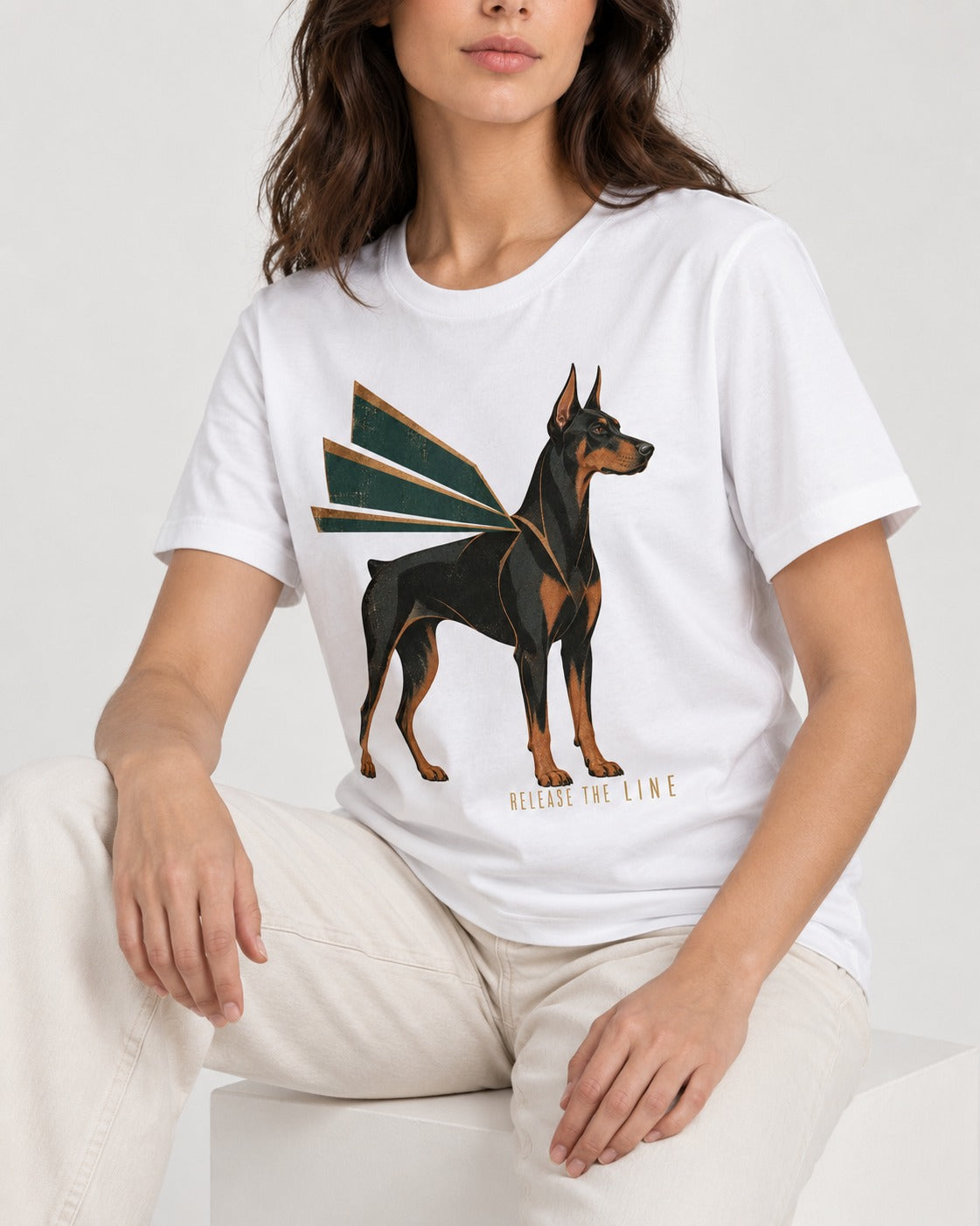 Release the Doberman Line T-Shirt in White, worn by a seated model