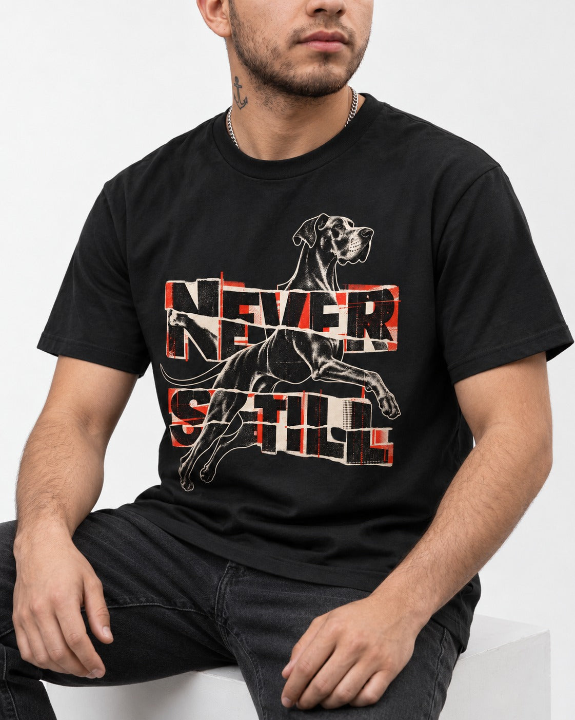 Great Dane Never Still Leaping Collage Graphic T-Shirt in Black, worn by a seated model