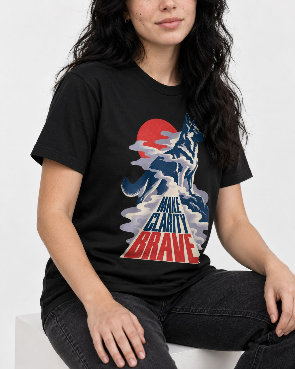 Make Clarity Brave Mountain German Shepherd Dog Graphic T-Shirt in Black, worn by a seated model