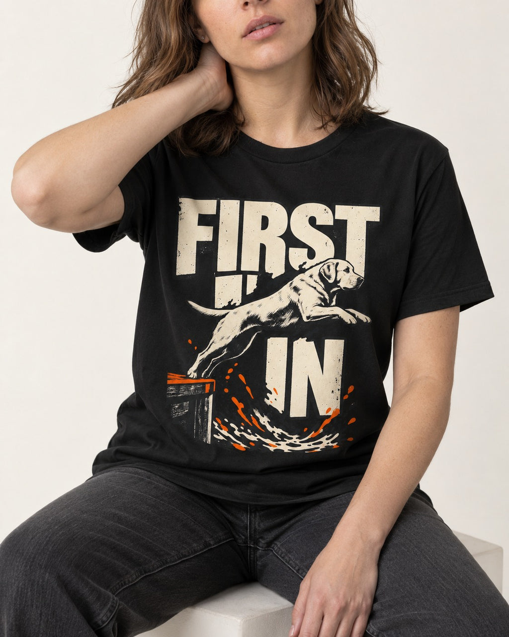 First In Dock Jump Labrador Retriever Graphic T-Shirt in Black, worn by a seated model