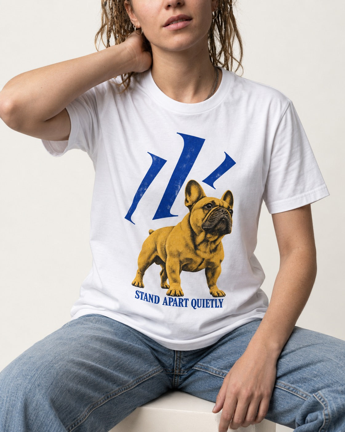 Frenchie Stand Apart Quietly T-Shirt in White, worn by a seated model