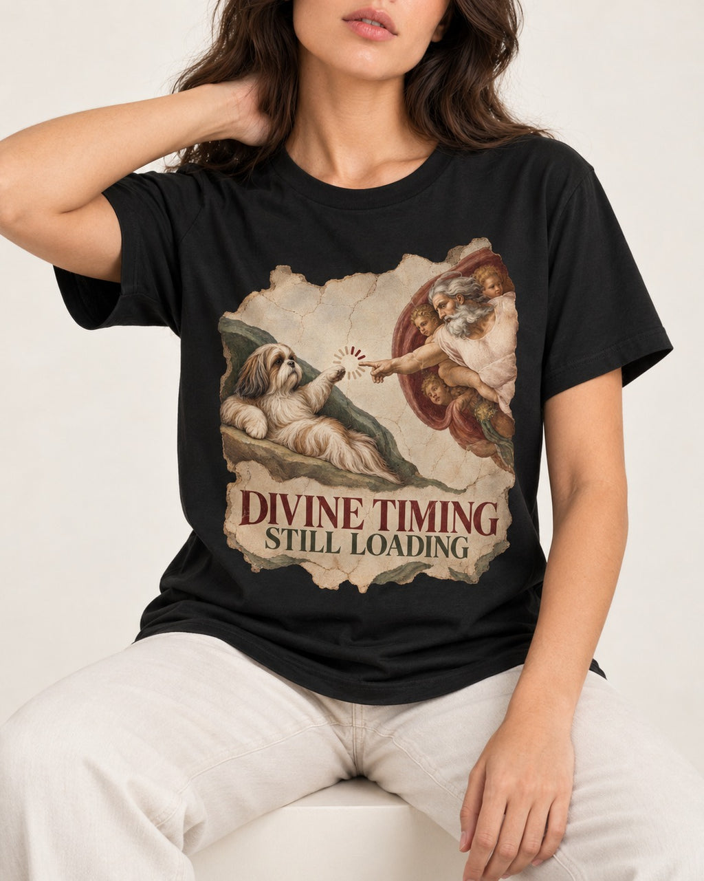 Shih Tzu Divine Timing Still Loading Renaissance Parody Graphic T-Shirt in Black, worn by a seated model