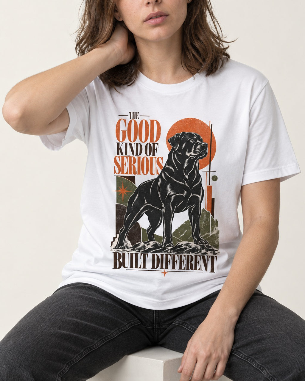 Rottweiler Built Different T-Shirt in White, worn by a seated model