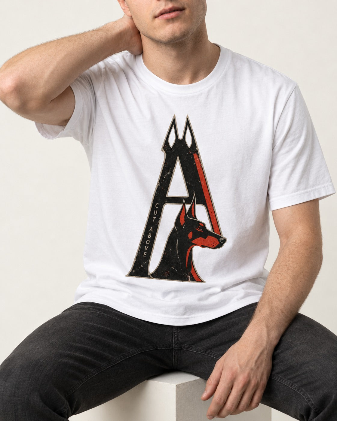 Doberman A Cut Above T-Shirt in White, worn by a seated model
