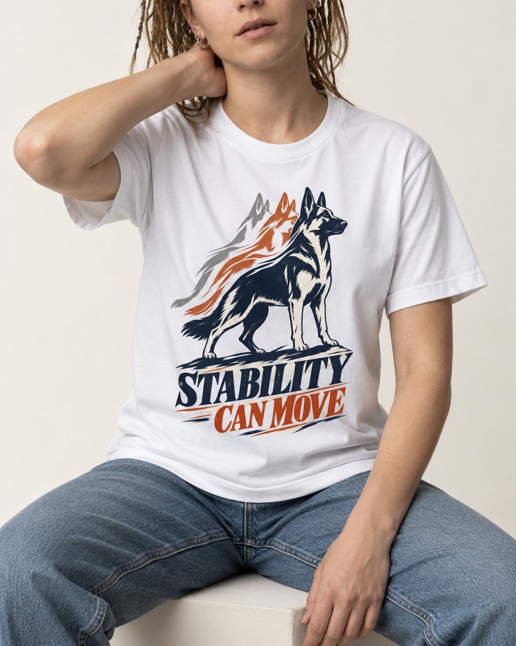 Stability Can Move German Shepherd Dog T-Shirt in White, worn by a seated model
