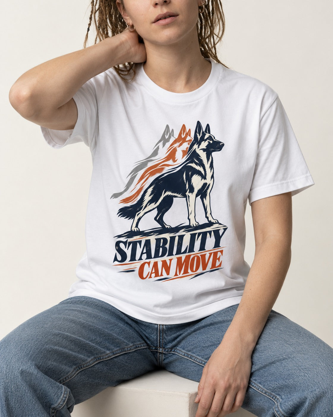 Stability Can Move German Shepherd Dog T-Shirt in White, worn by a seated model