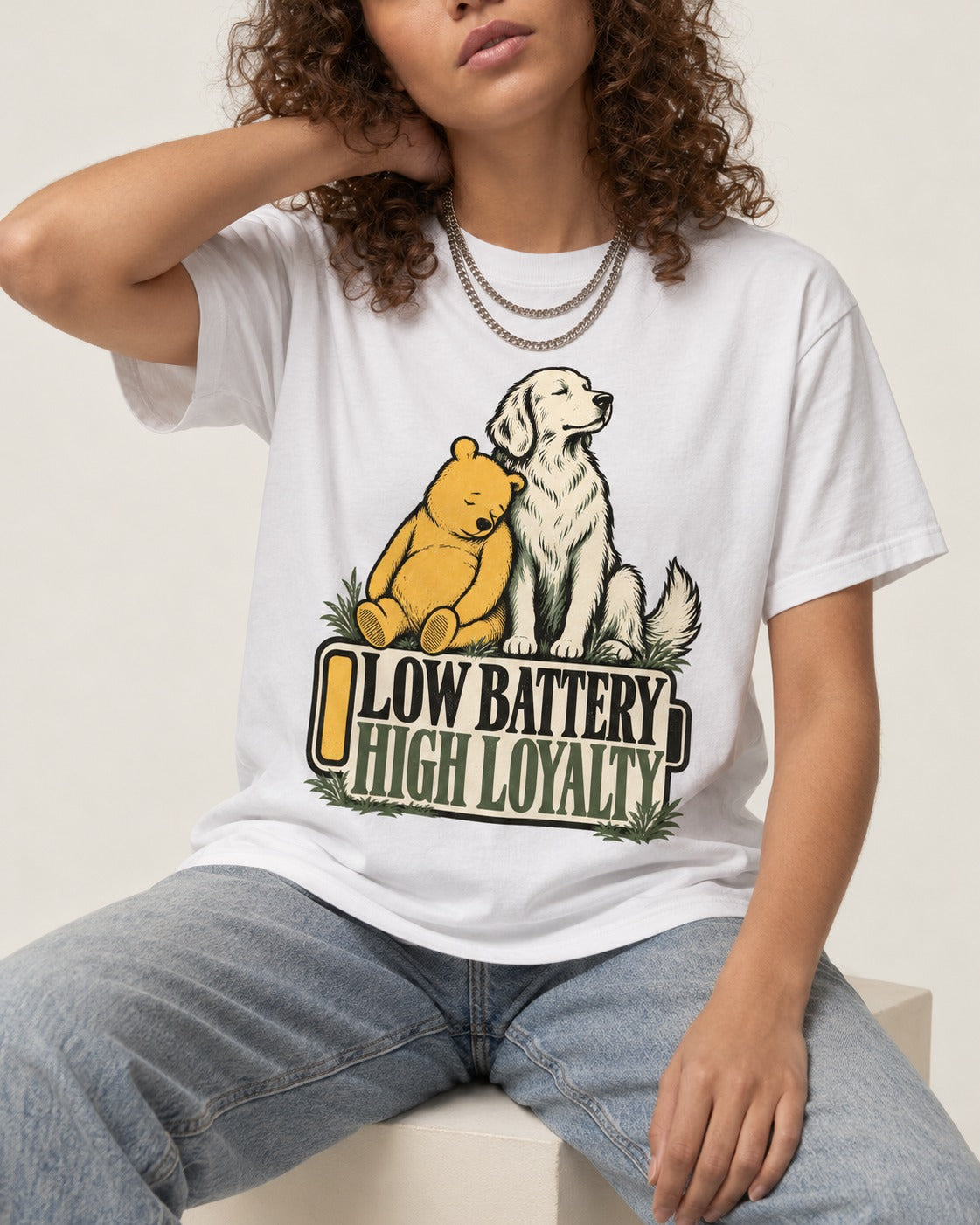 Golden Retriever Low Battery High Loyalty T-Shirt in White, worn by a seated model