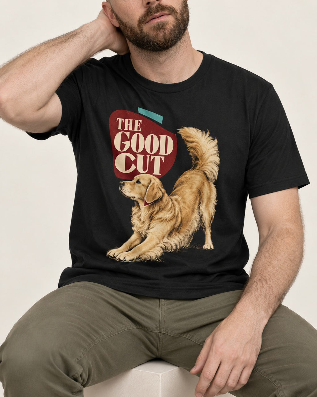 Golden Retriever The Good Cut Play Bow Graphic T-Shirt in Black, worn by a seated model