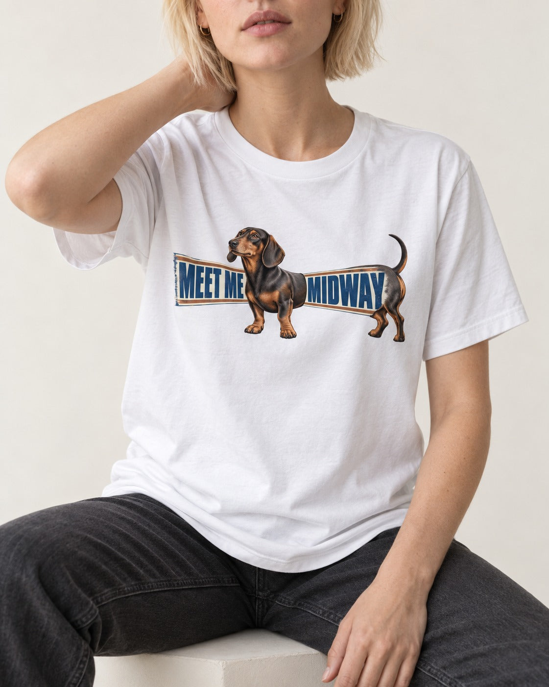 Dachshund Meet Me Midway T-Shirt in White, worn by a seated model
